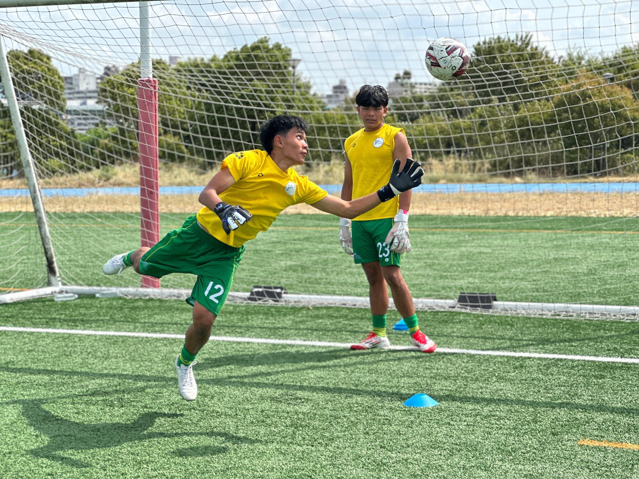 May be an image of 2 people, people playing football, people playing soccer, grass and text