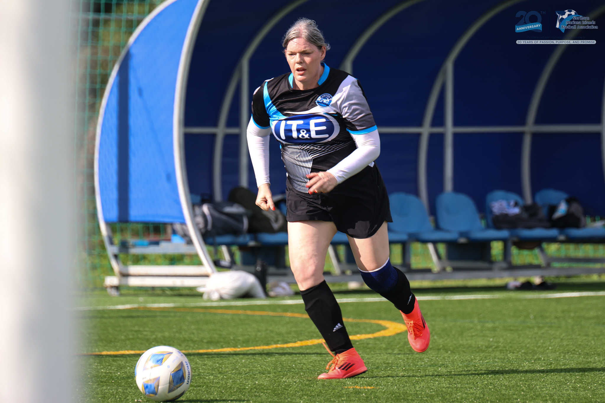 May be an image of 1 person, playing soccer, playing football, grass and text