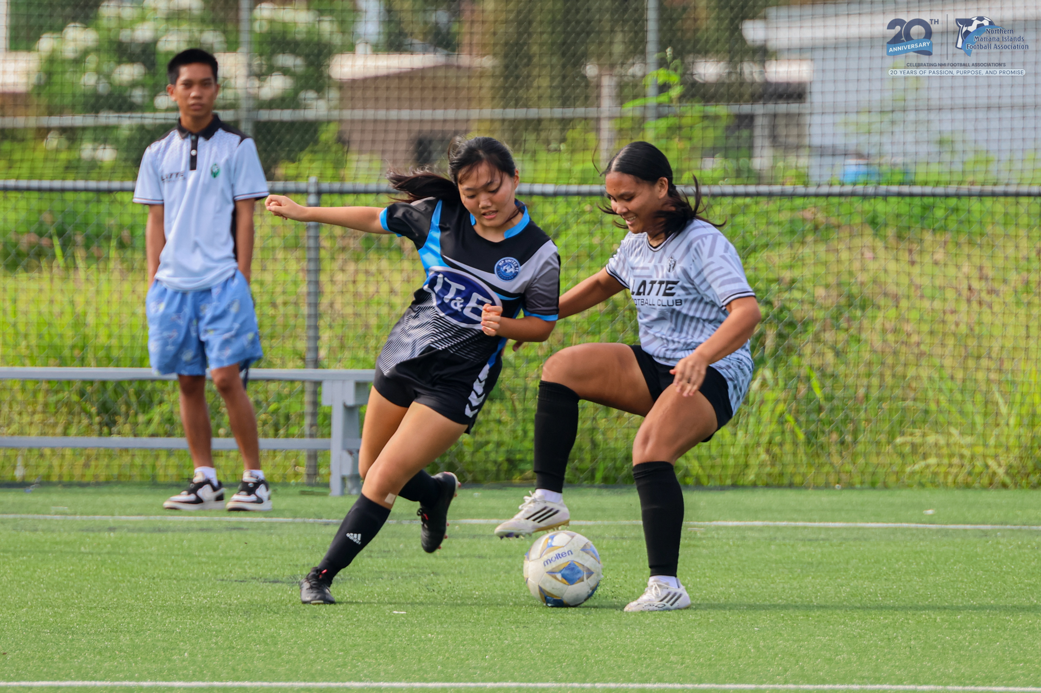 May be an image of 3 people, people playing football, people playing soccer, grass and text