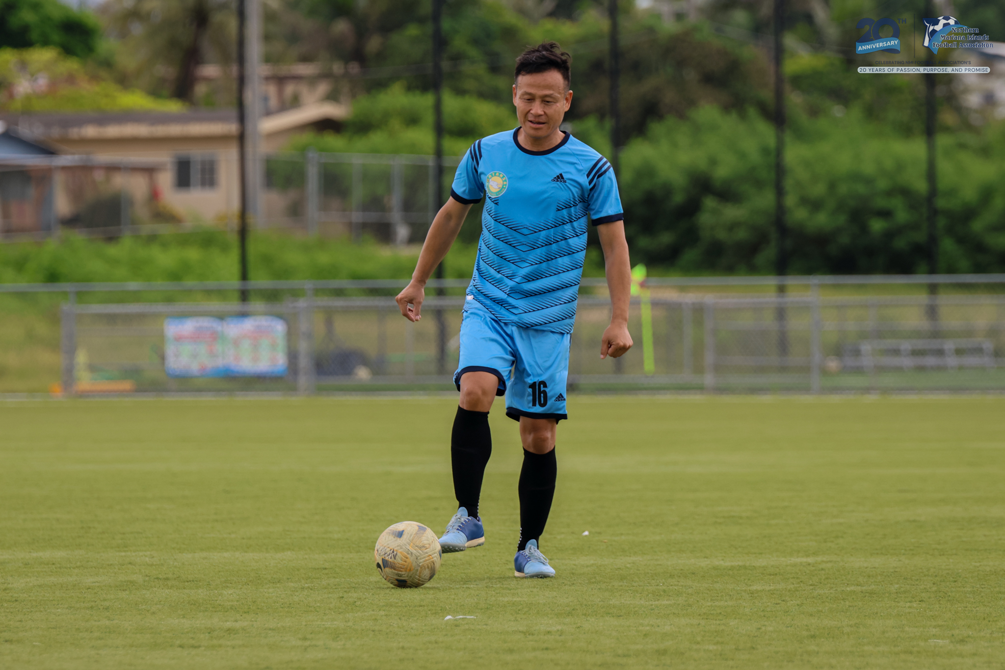 May be an image of 1 person, playing soccer, playing football, grass and text