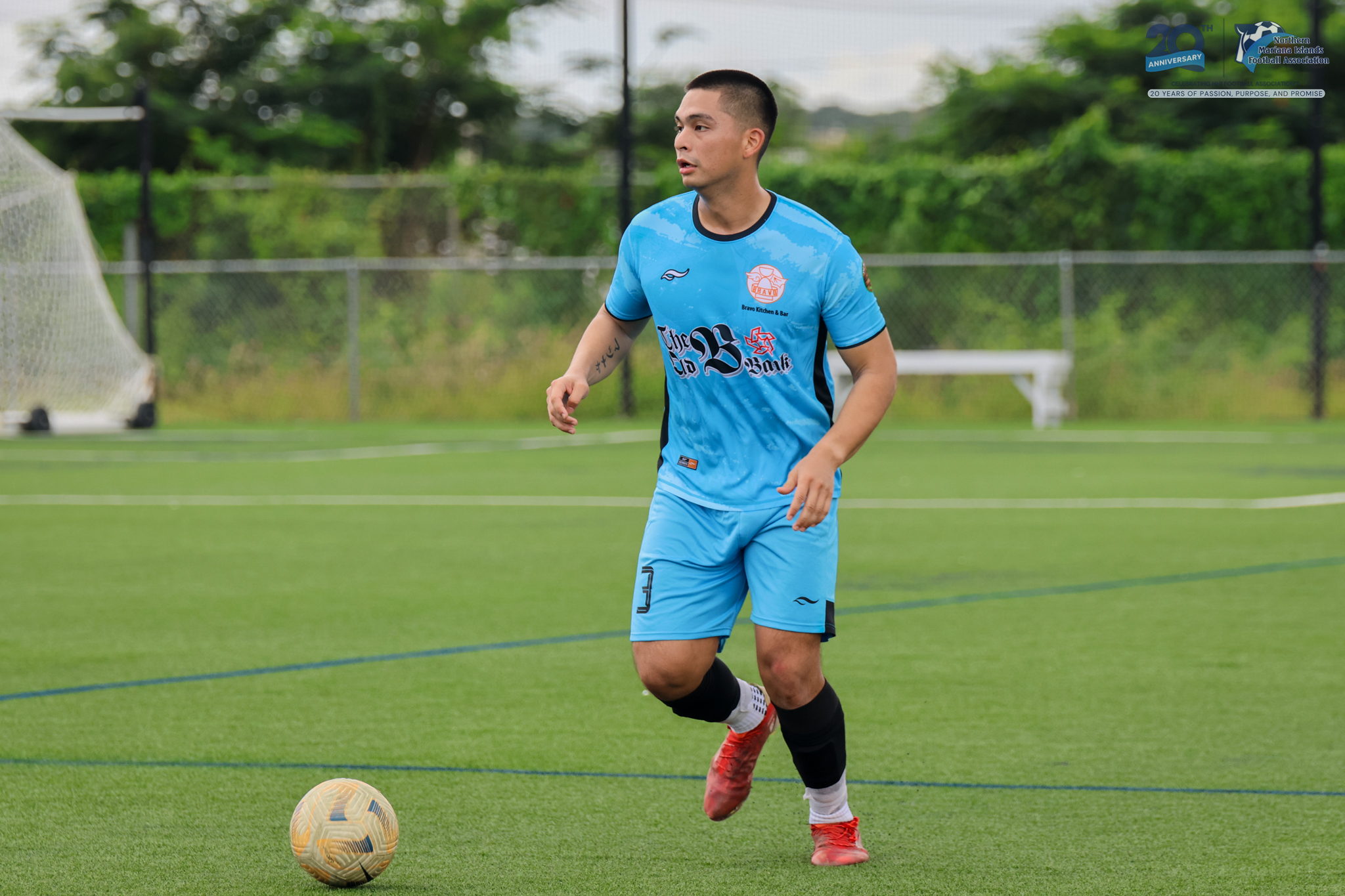 May be an image of 1 person, playing soccer, playing football, grass and text