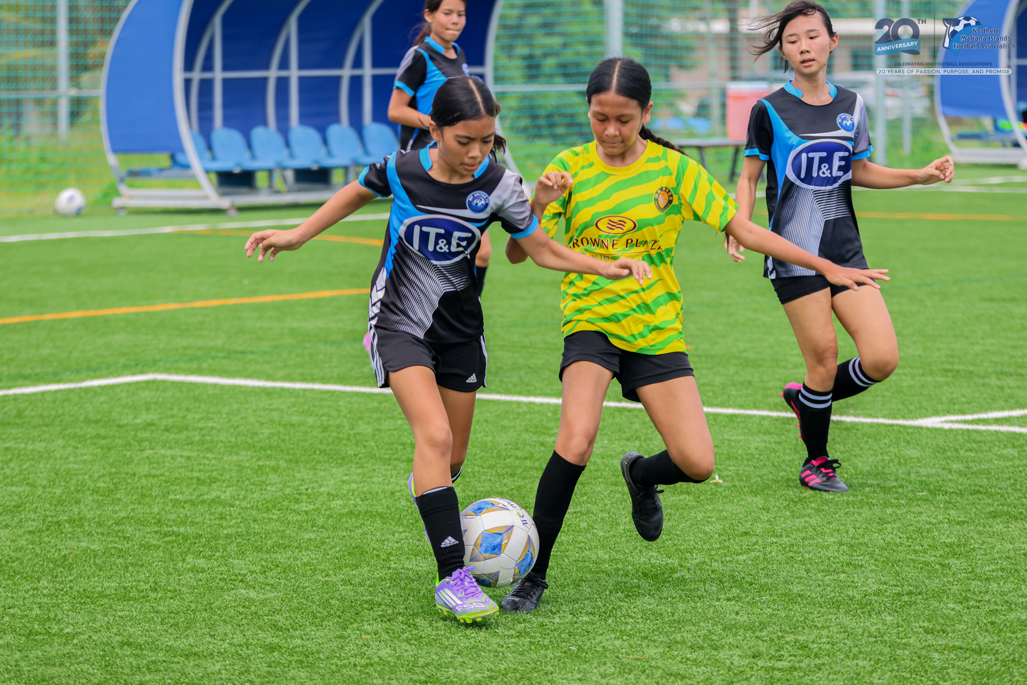 May be an image of 3 people, people playing football, people playing soccer, grass and text