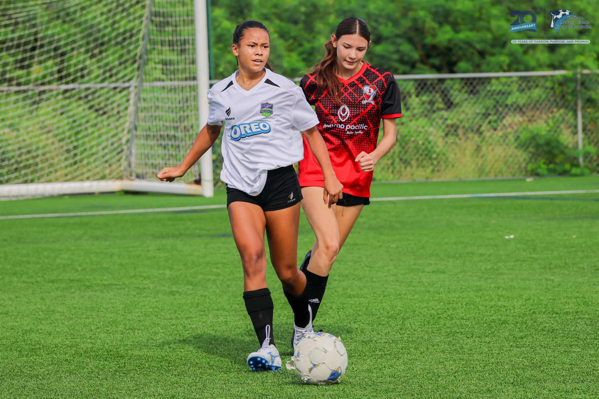 May be an image of 2 people, people playing soccer, people playing football, grass and text