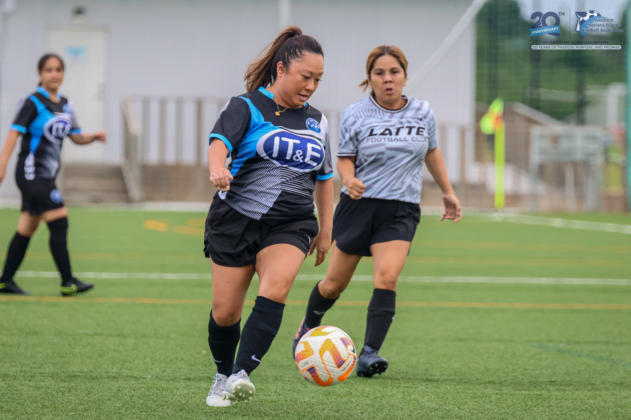 May be an image of 3 people, people playing football, people playing soccer, grass and text
