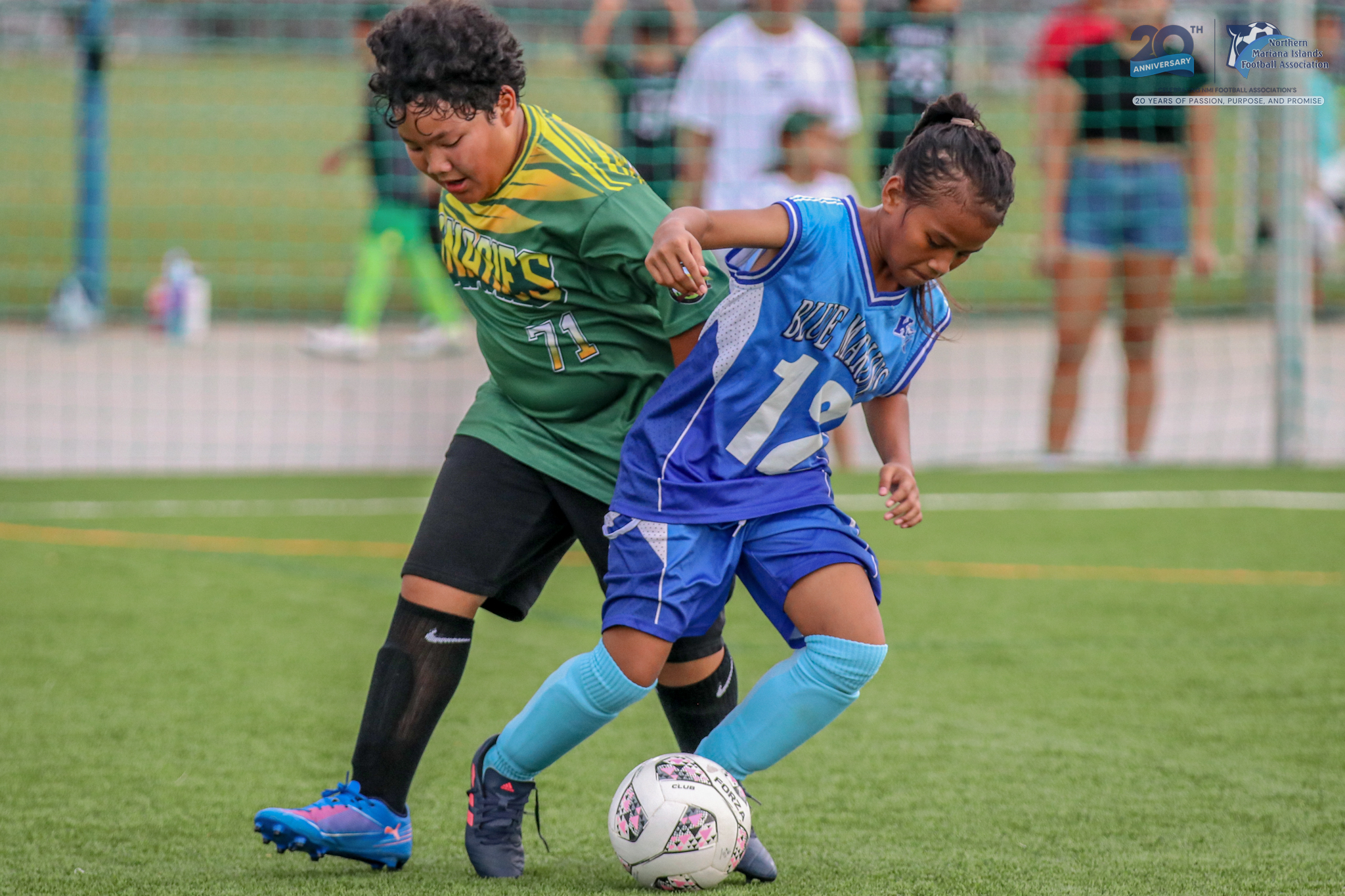 May be an image of 3 people, people playing football, people playing soccer, grass and text