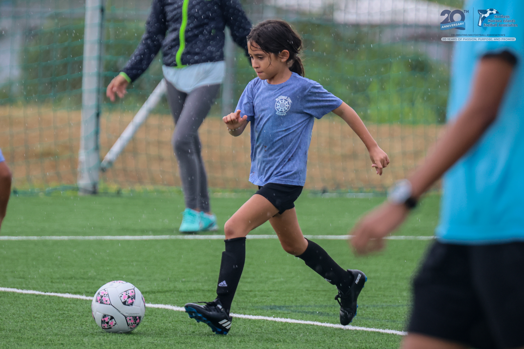 May be an image of 3 people, people playing football, people playing soccer, grass and text