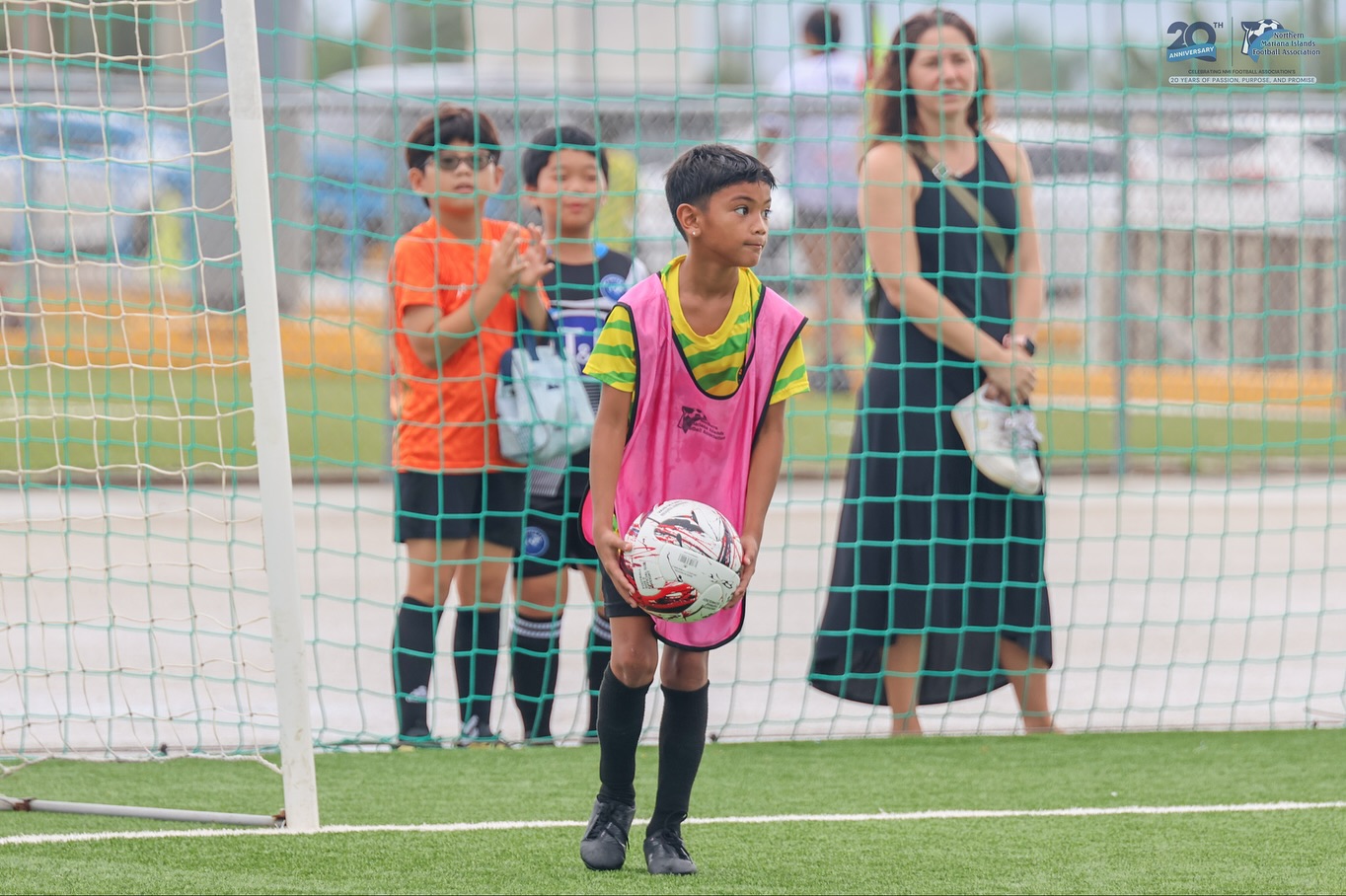 May be an image of 4 people, child, people playing soccer, people playing football, grass and text