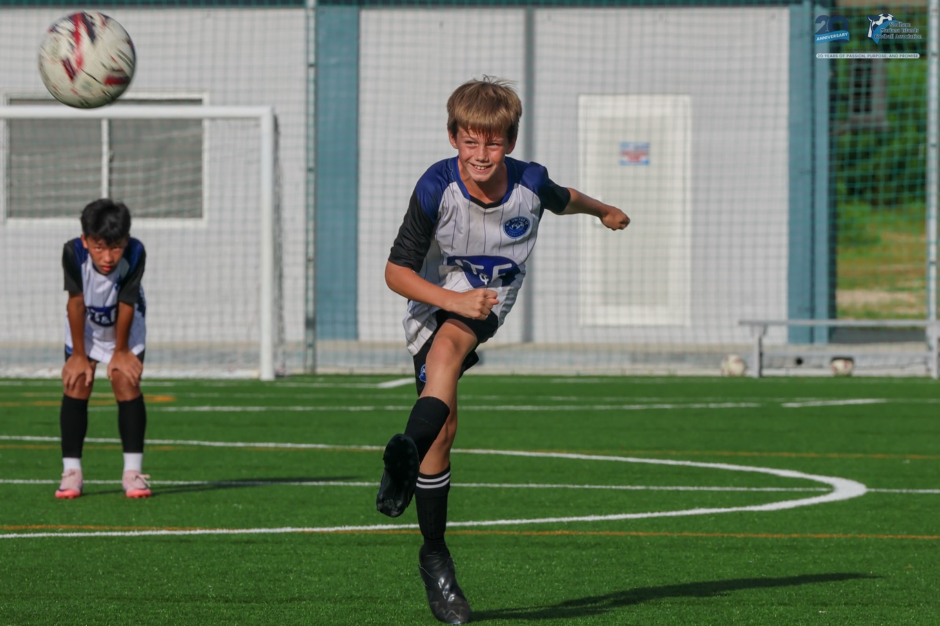 May be an image of 2 people, people playing soccer, people playing football, grass and text