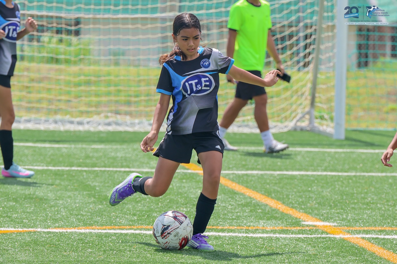 May be an image of 4 people, people playing soccer, people playing football, grass and text