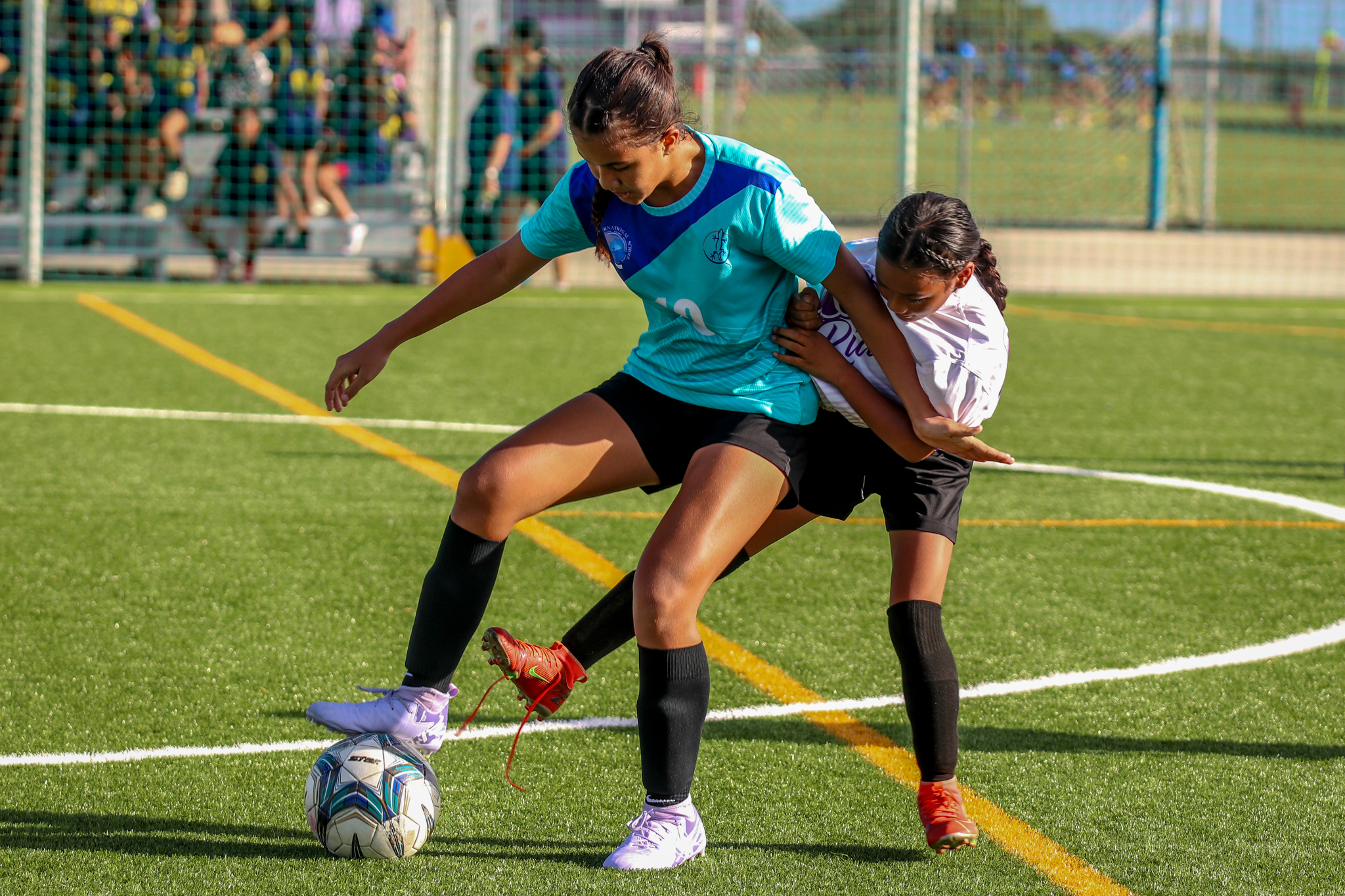 May be an image of 2 people, people playing soccer, people playing football, grass and text