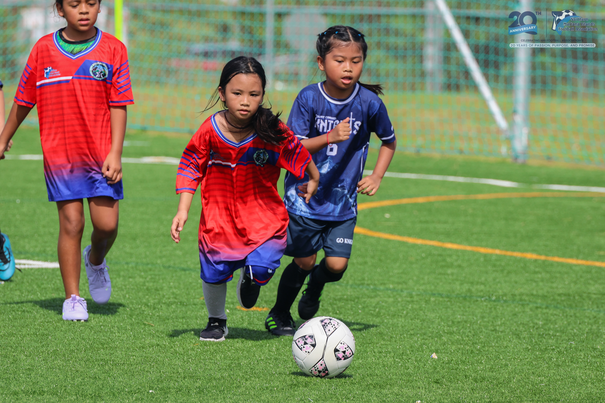 May be an image of 3 people, people playing football, people playing soccer, grass and text