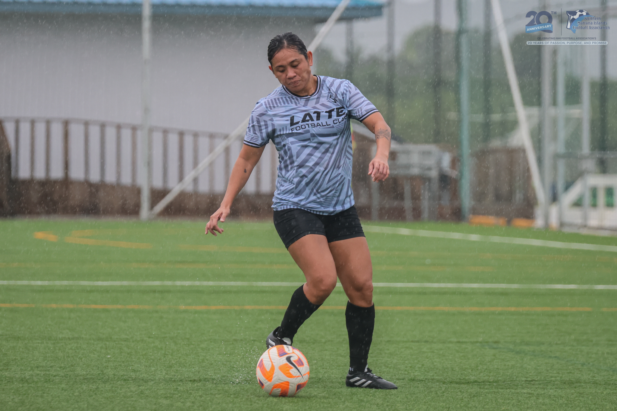 May be an image of 1 person, playing football, playing soccer, grass and text