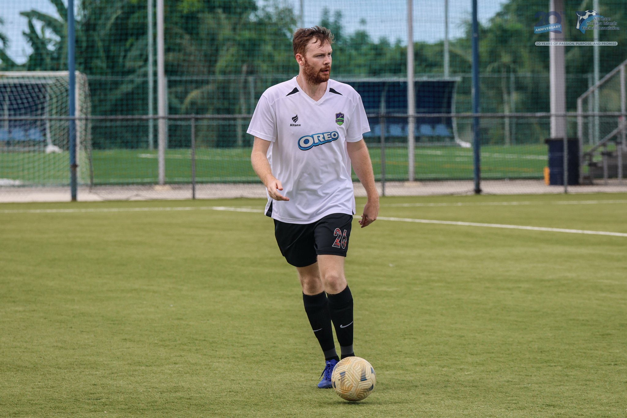 May be an image of 1 person, playing football, playing soccer, grass and text