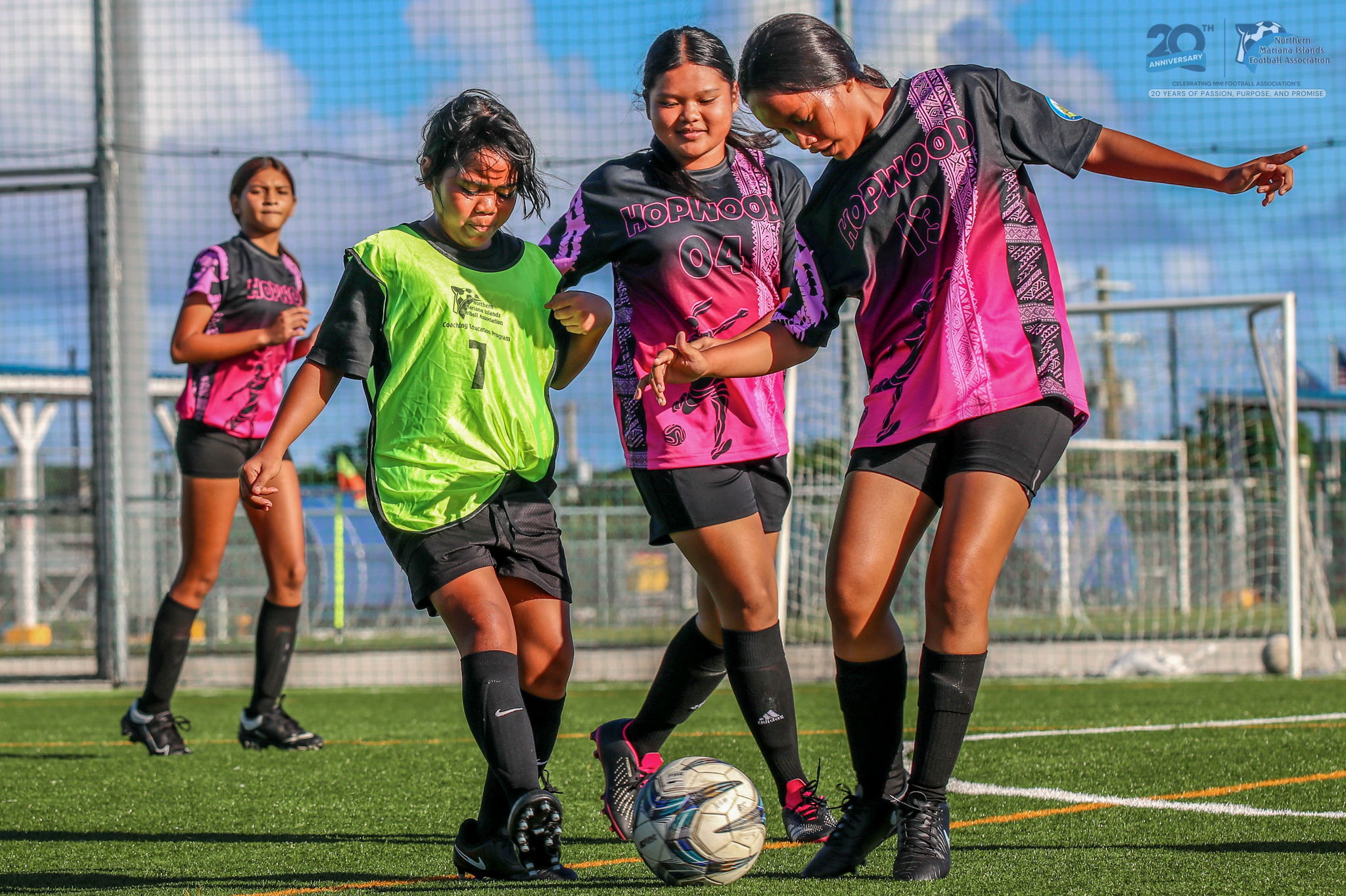 May be an image of 4 people, people playing football, people playing soccer, grass and text