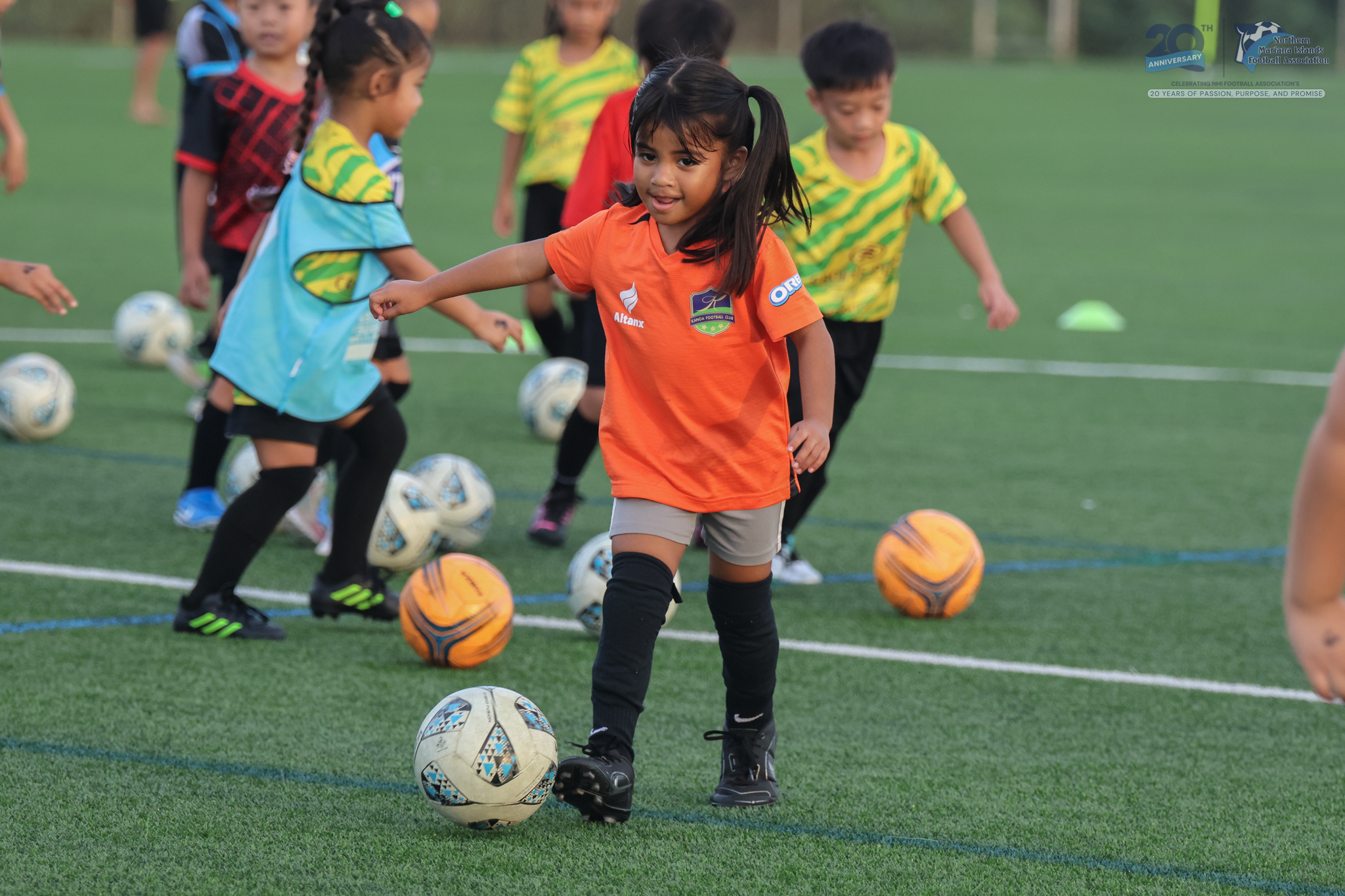 May be an image of 5 people, child, people playing soccer, people playing football, grass and text