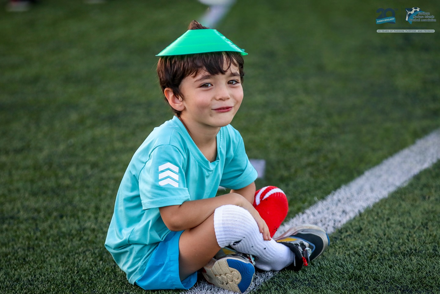 May be an image of child, football, soccer and text